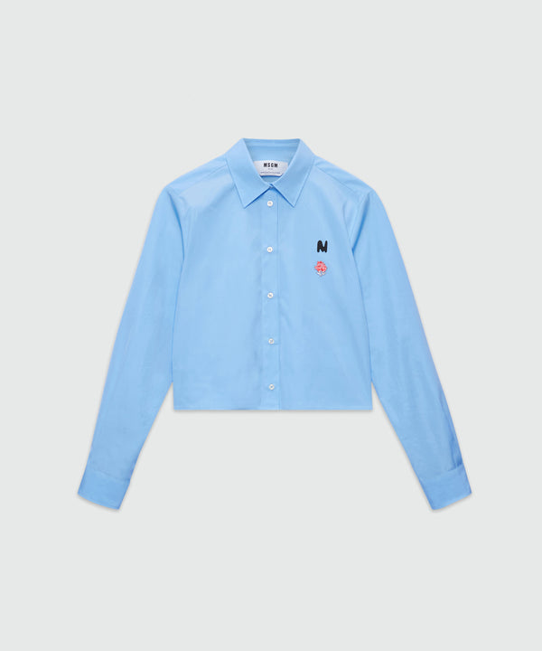 Light blue cropped poplin shirt with "TheMwave" embroidery and pink patch