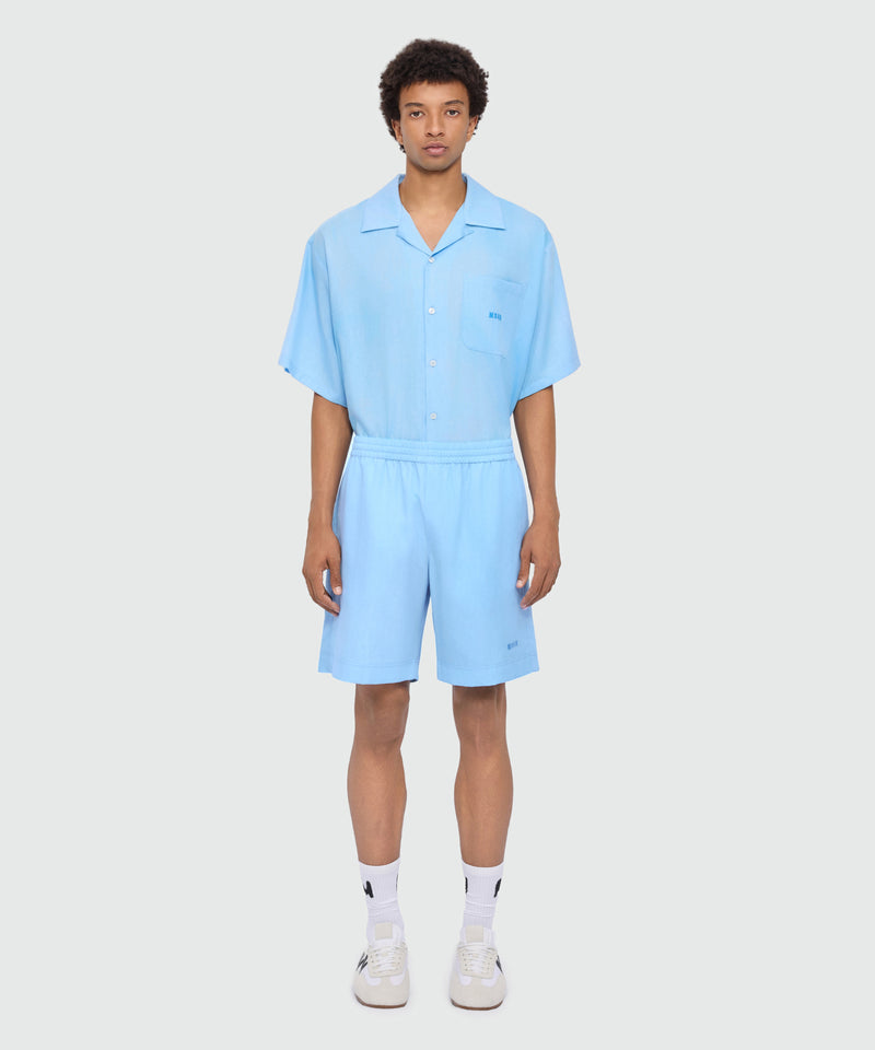 Light blue lyocell Bermuda shorts with tie-dye effect treatment and embroidered logo at the hem. 84 Uomo 
