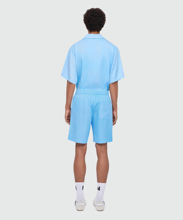 Light blue lyocell Bermuda shorts with tie-dye effect treatment and embroidered logo at the hem.