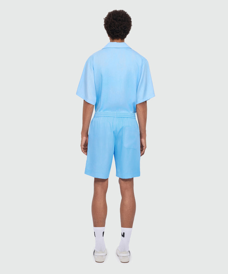 Light blue lyocell Bermuda shorts with tie-dye effect treatment and embroidered logo at the hem. 84 Uomo 
