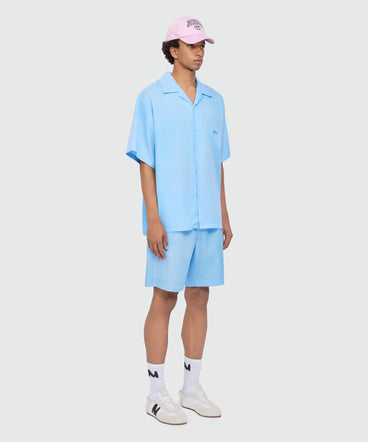 Light blue lyocell Bermuda shorts with tie-dye effect treatment and embroidered logo at the hem.