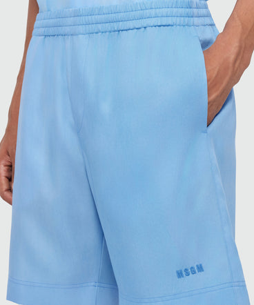 Light blue lyocell Bermuda shorts with tie-dye effect treatment and embroidered logo at the hem.