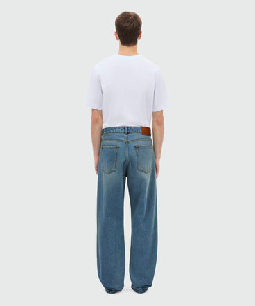 Medium-wash denim trousers with localized distressing, five-pocket design